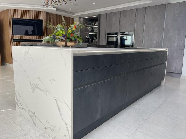 Luxury modern kitchen with marble-effect island, grey cabinetry and wood wall panelling