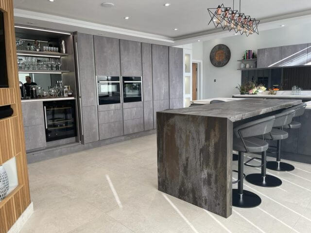 Contemporary grey kitchen with large island, bar seating and built-in appliances