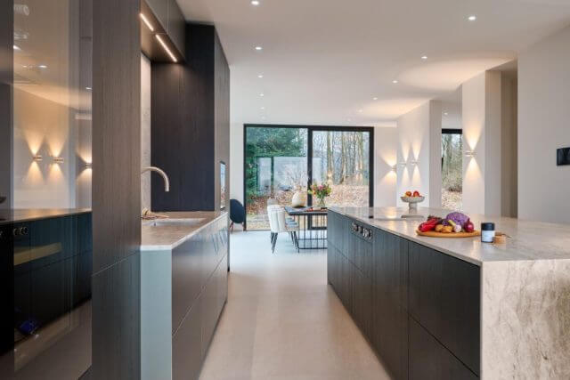 Luxury dark handleless kitchen with marble-effect worktops and open-plan dining space