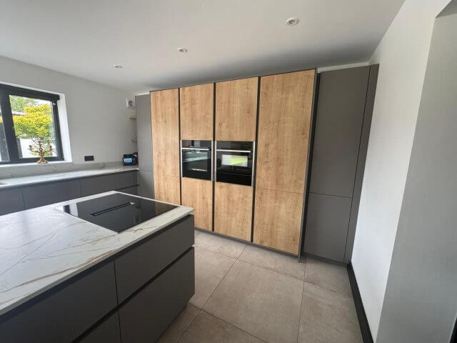 Dark shaker kitchen with white island and wine cooler by Tolle Kitchens