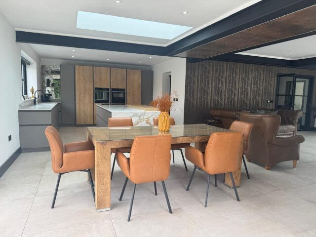 Open-plan kitchen and dining area with wood cabinetry and marble-effect island