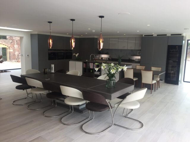 Large open-plan kitchen diner with dark dining table and pendant lighting