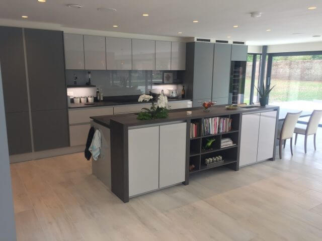 Open-plan grey handleless kitchen with island unit featuring open shelving and dark wood worktop in a Yorkshire home
