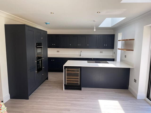 Dark shaker kitchen with white island and integrated wine cooler