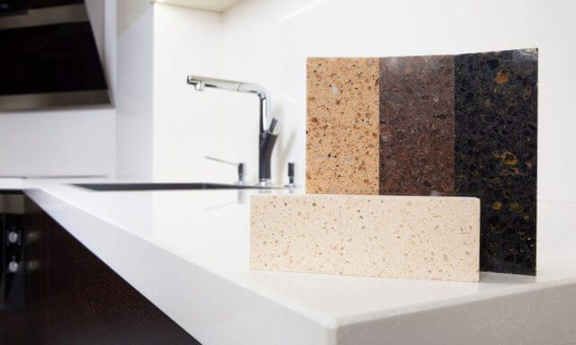 Quartz worktop material samples in cream, brown and black showing texture and colour options for kitchen surfaces